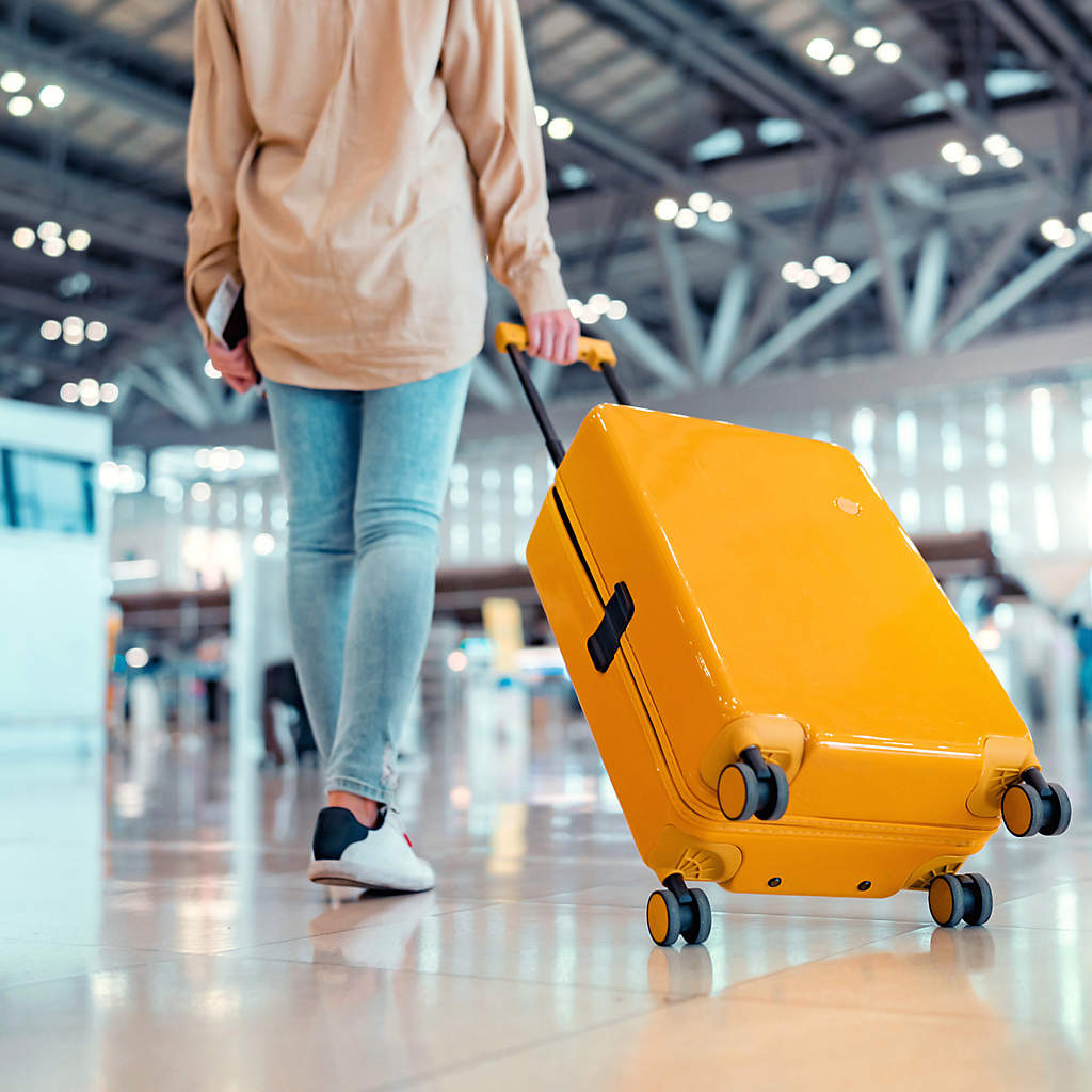 DIR-woman-traveler-passenger-walking-in-airport-with-yellow-suitcase