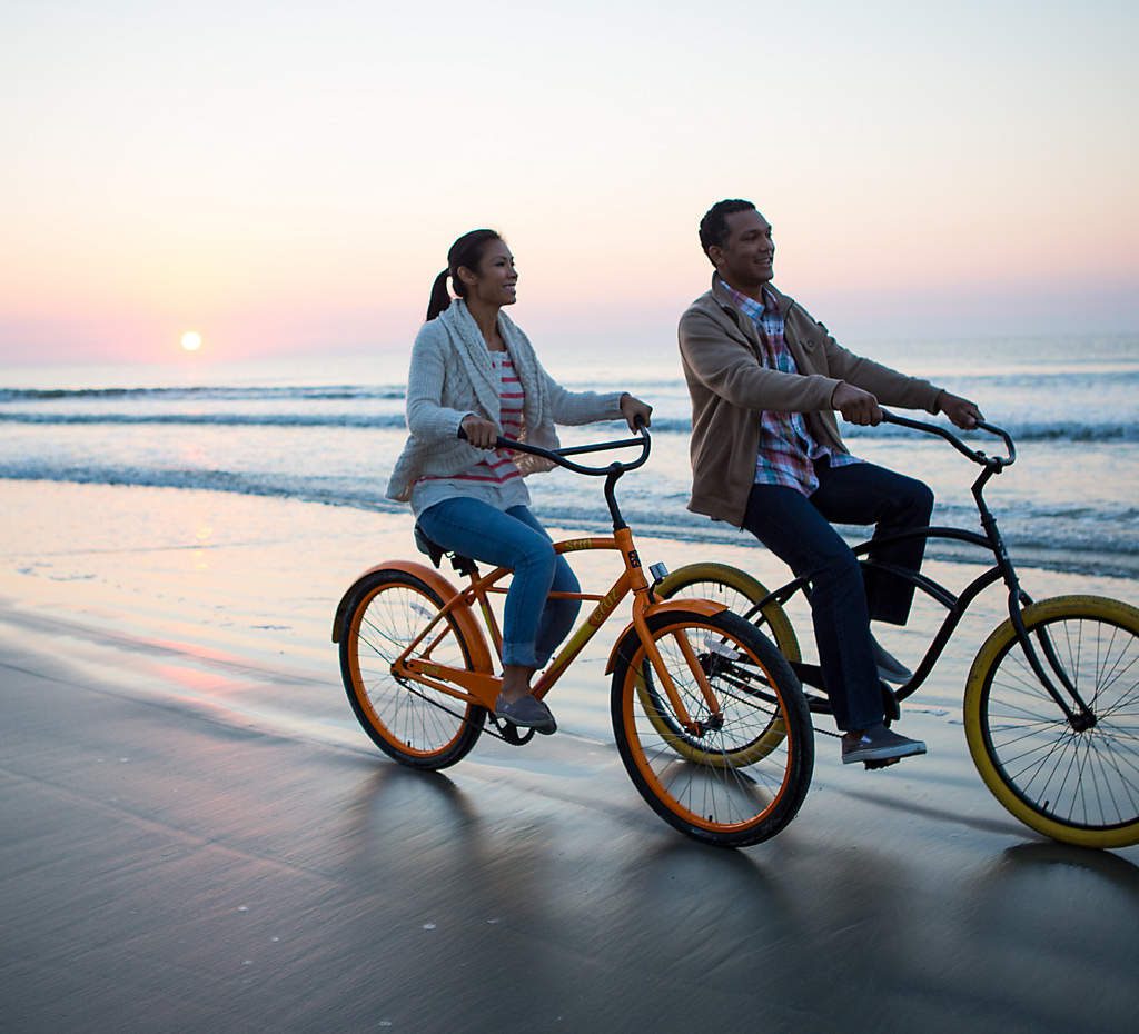 img-fwi-myrtle-beach-south-carolina-couple-bikes-beach-sunset-1